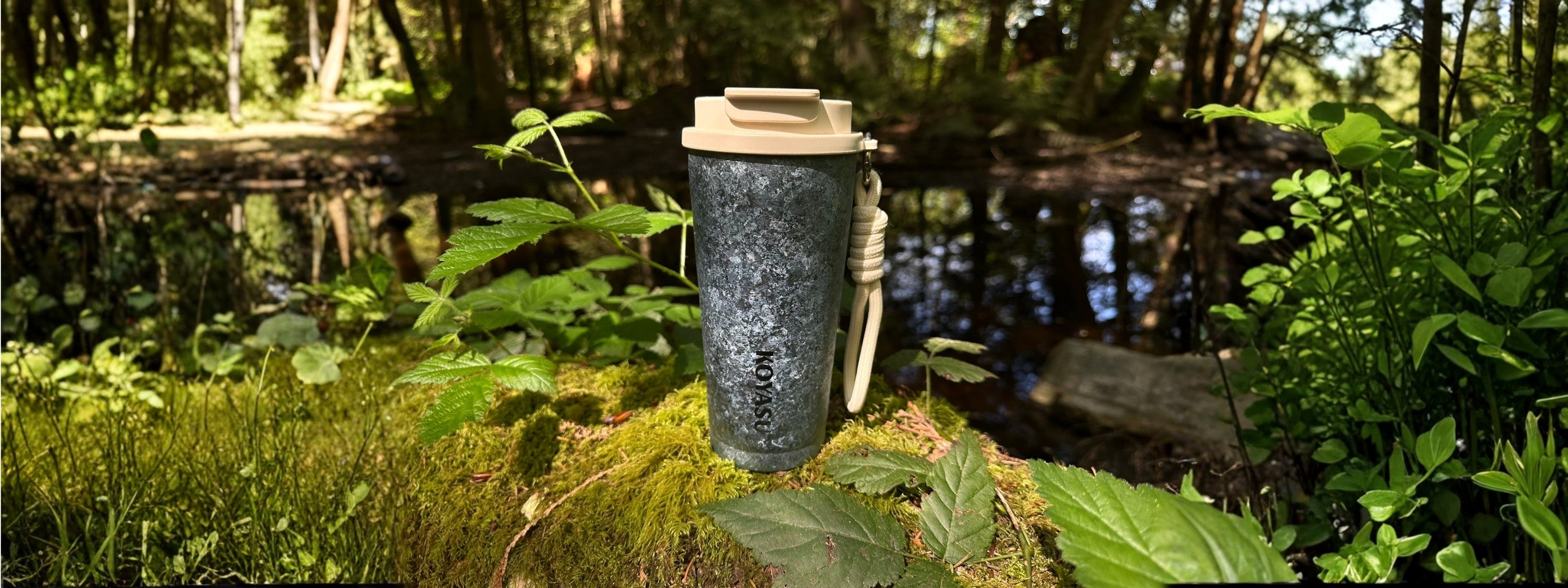 KOYASU® Ti-Zen™ 12oz pure titanium coffee mug held by hand on a misty forest trail. Ultralight, double-wall vacuum insulated travel tumbler with raw crystal titanium texture for camping, hiking, and outdoor adventures.