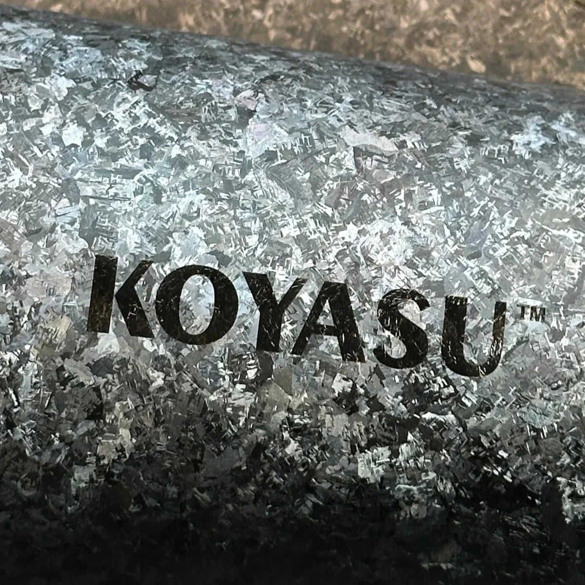 Close-up of KOYASU whole-body titanium mug surface showing unique flake texture and engraved logo, no coating or polish